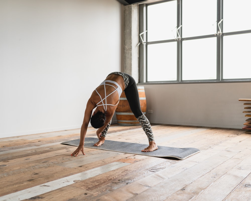 a person doing a handstand on a yoga mat