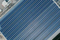 Wide-angle view of an industrial solar EPC project with rows of solar panels under bright sunlight.