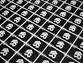 A grid of identical black cards with a white geometric logo, arranged diagonally. The cards have text at the bottom corners, and the logo consists of three cascading arrow-like shapes.