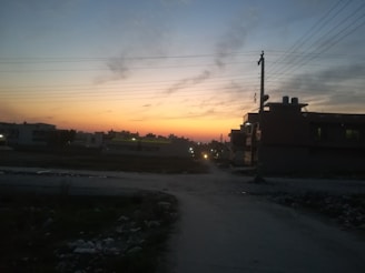 A technician installing fiber optic cables on a residential street at sunset.