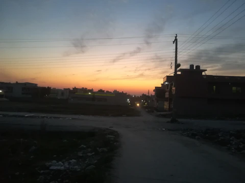 Solar-powered streetlights lining a quiet urban street at dusk.