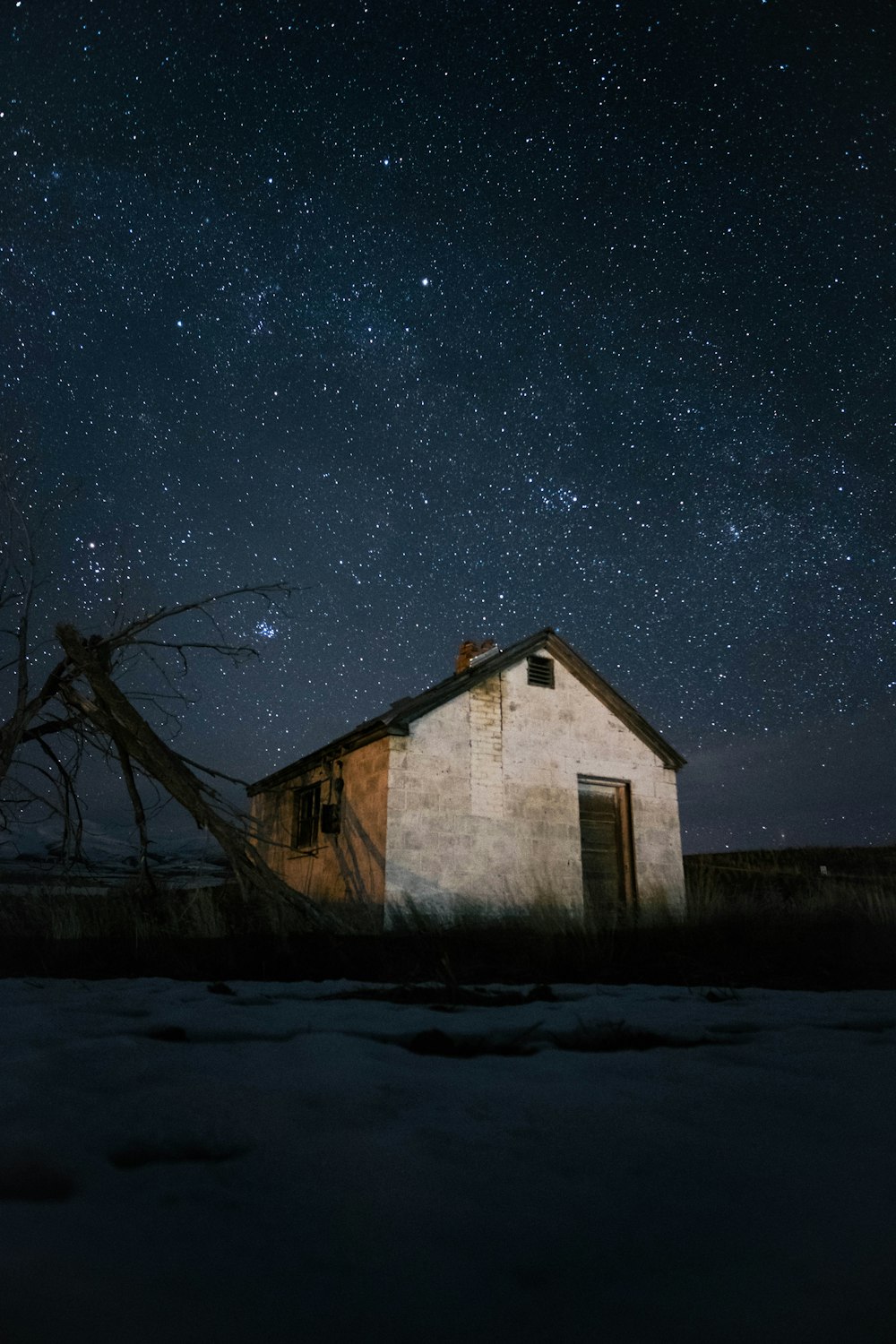 house under clear sky full of stars at night