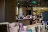 A mentor and student engaged in a lively conversation over books in a cozy library corner.
