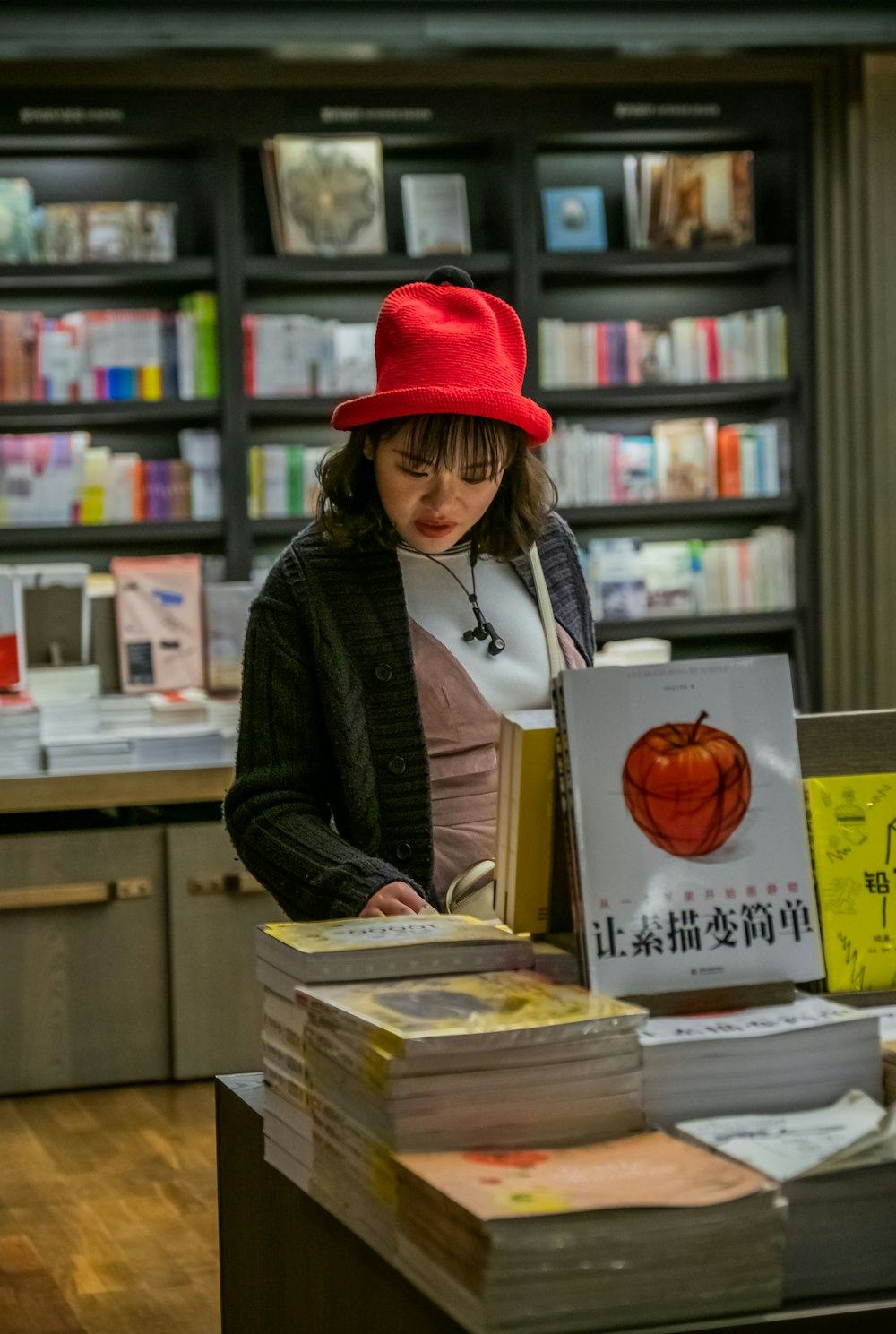 woman with red hat checking books on display