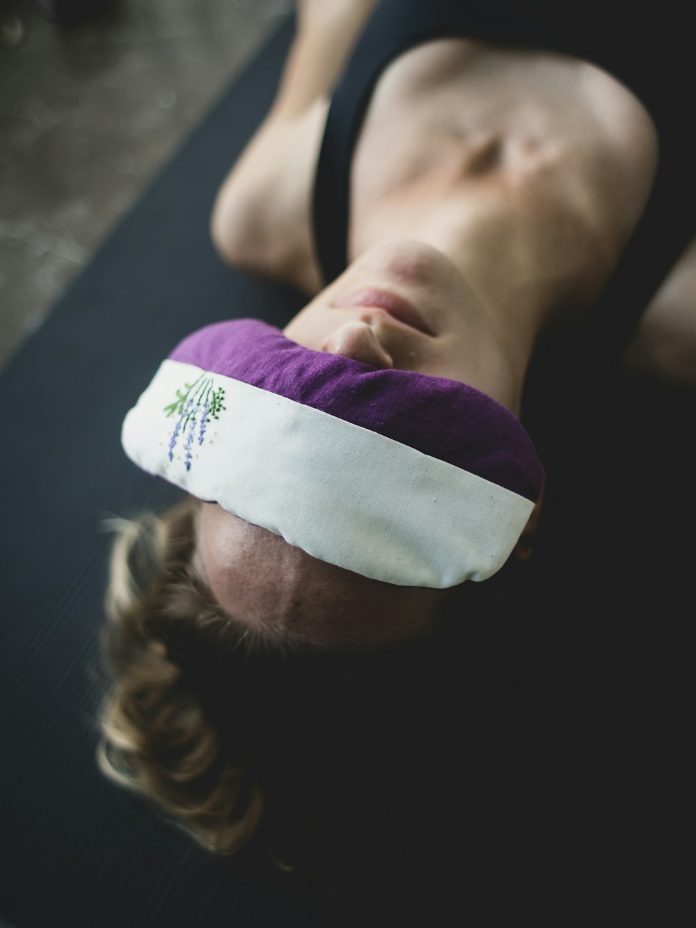 woman put purple and white pad on her forehead