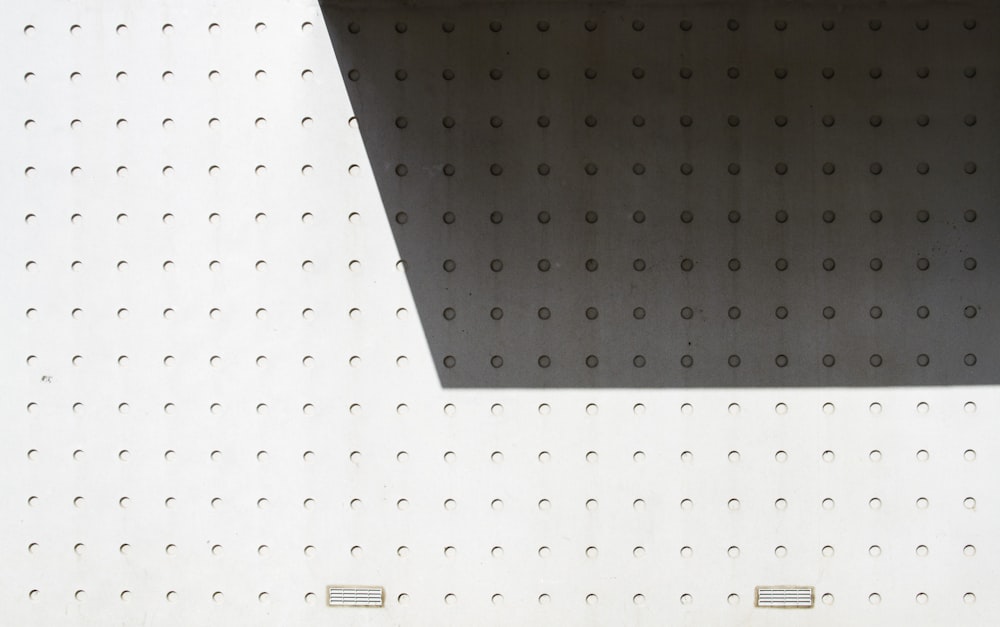 a bench sitting in front of a white wall