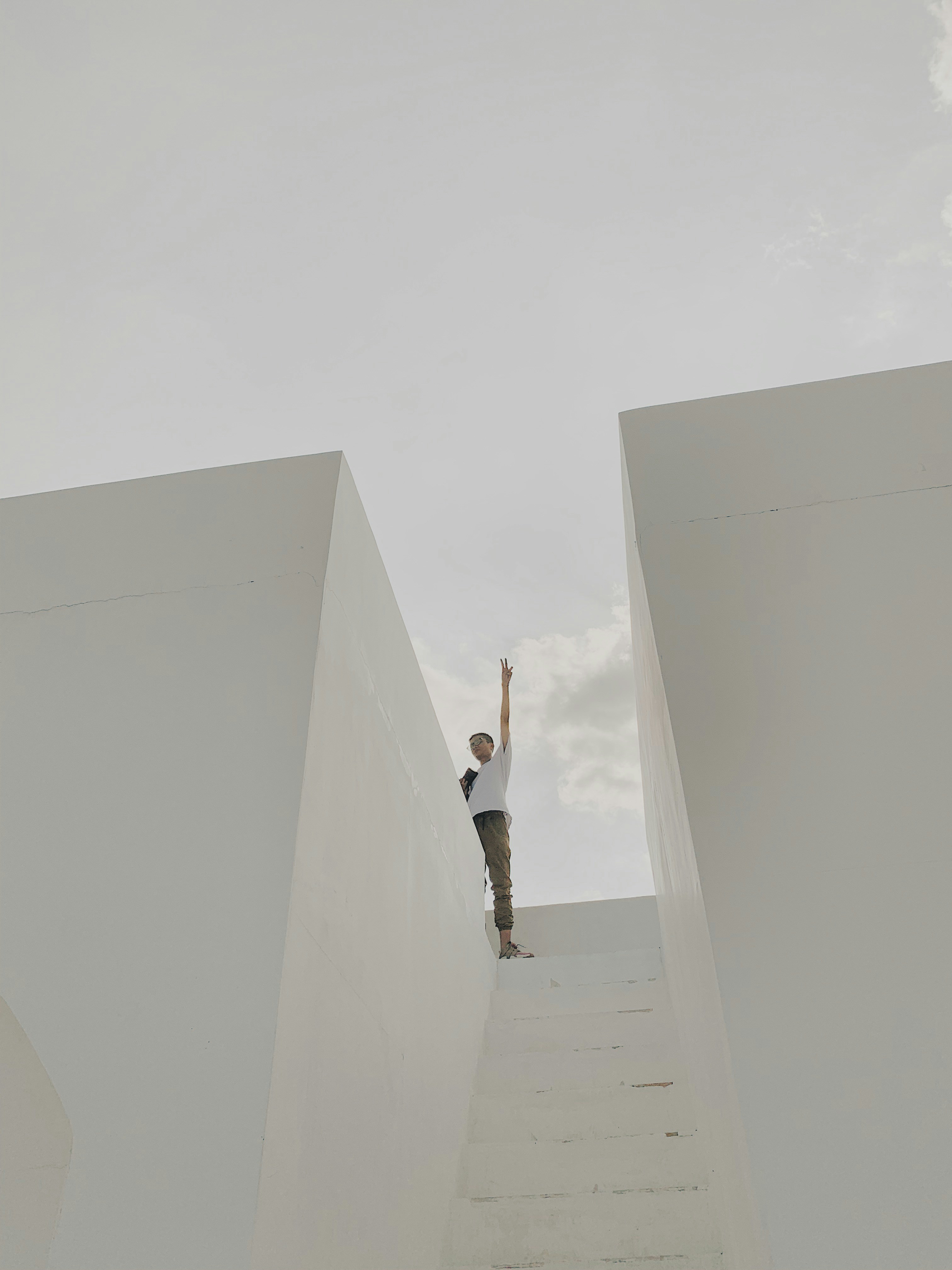 man in white stands on top of flight of stairs
