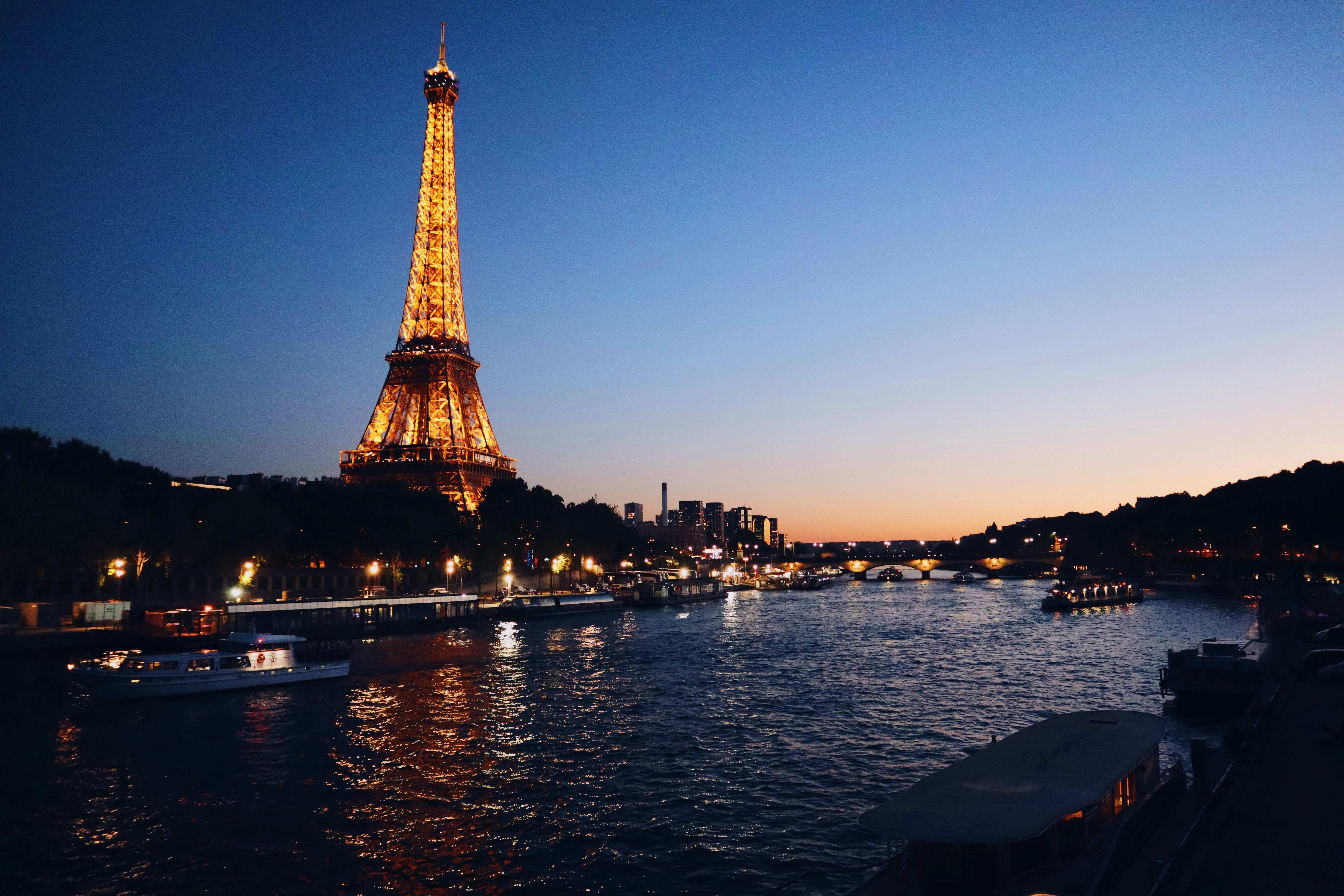 Eiffel Tower illuminated at sunset with Seine River in foreground