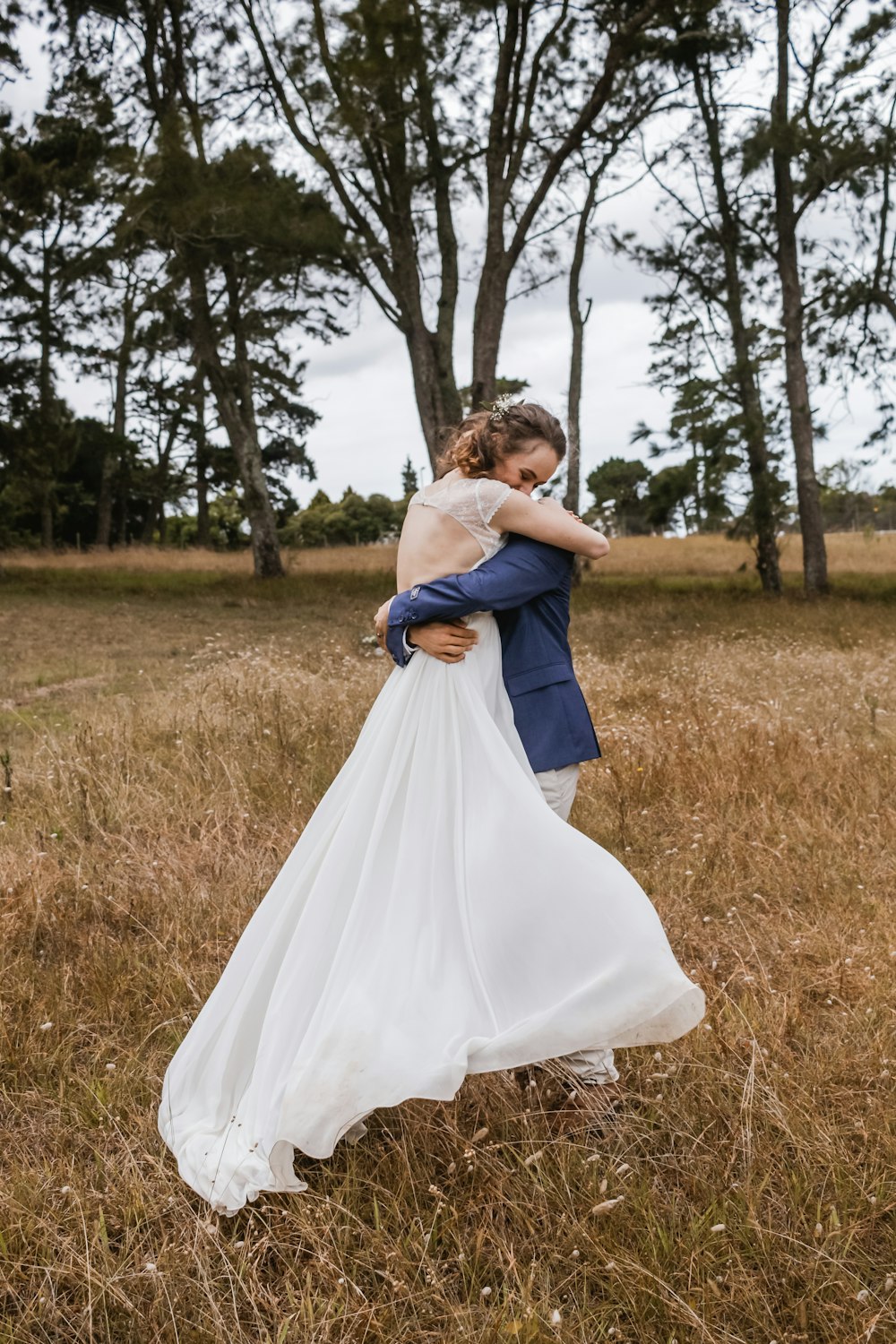 woman and man hugging in the middle of grass field
