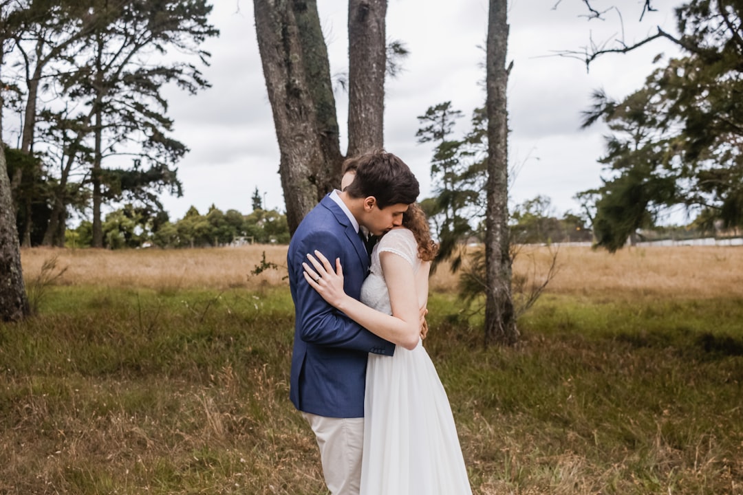 man hugging woman near tree