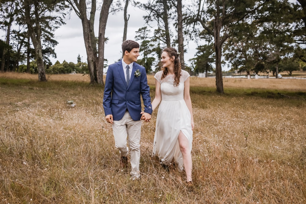 man and woman walking while holding hands