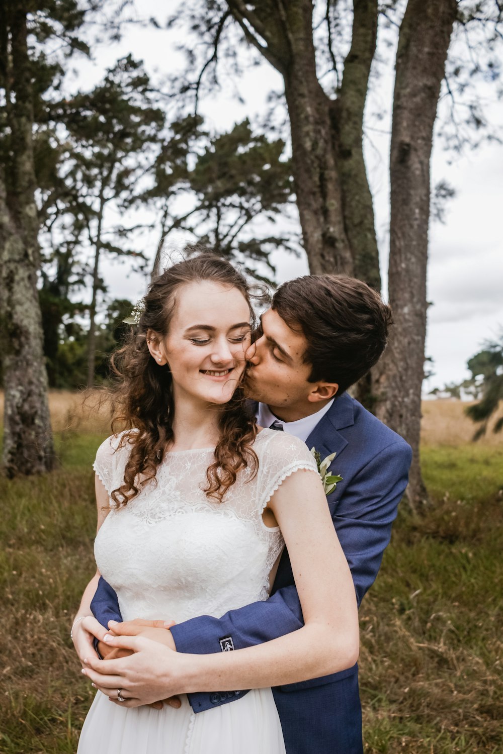 man kissing woman under tree