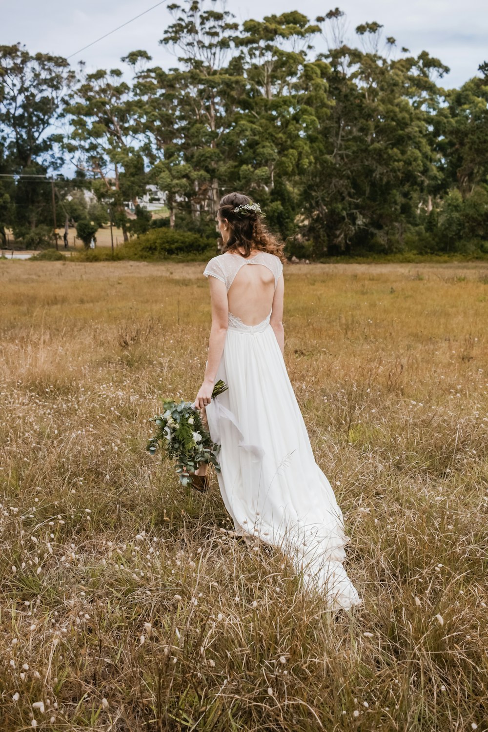 Foto Mujer con vestido blanco sin espalda con ramo de flores blancas y verdes – Imagen gratis en