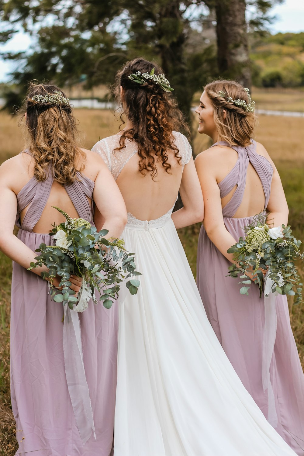 three women hiding flower bouquets