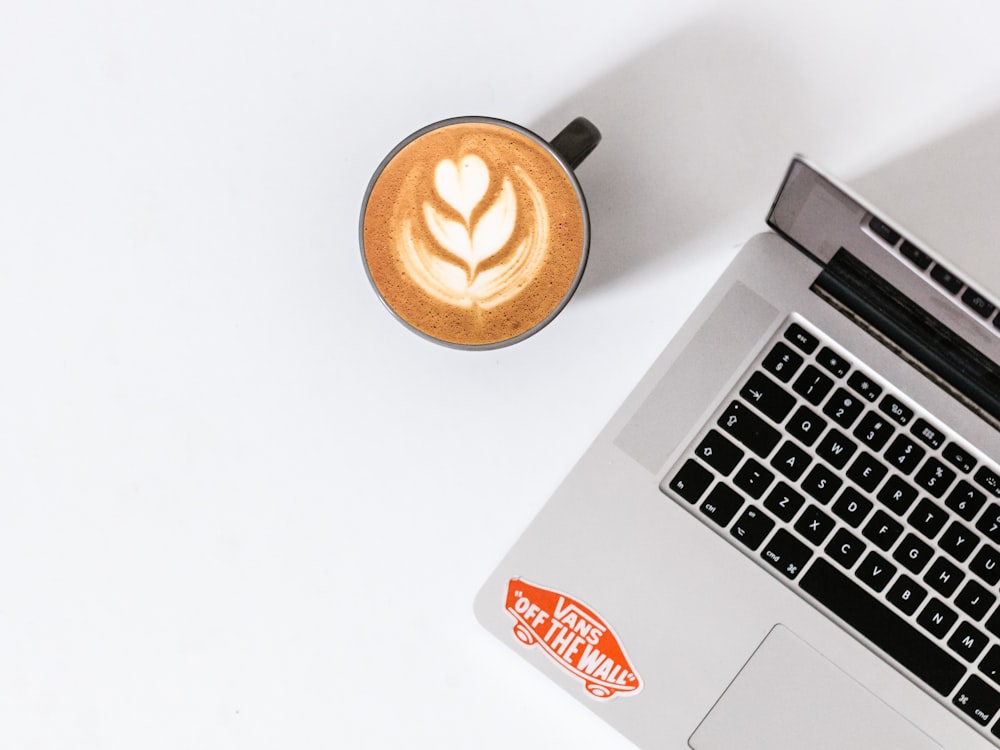 coffee latte beside MacBook