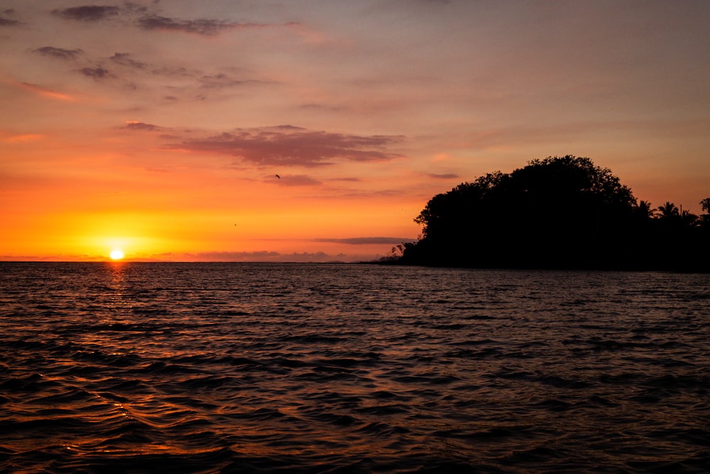 silhouette dell'isola con mare calmo durante il tramonto