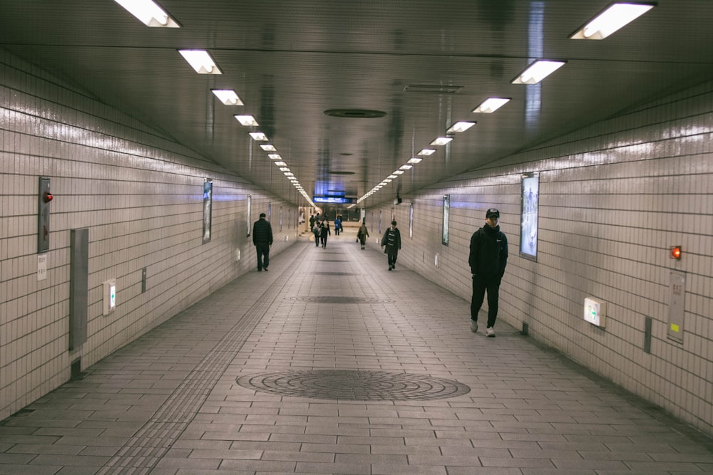 people walking under the subway