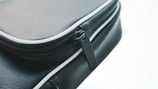 Close-up of a travel bag's sturdy zipper and leather handle.