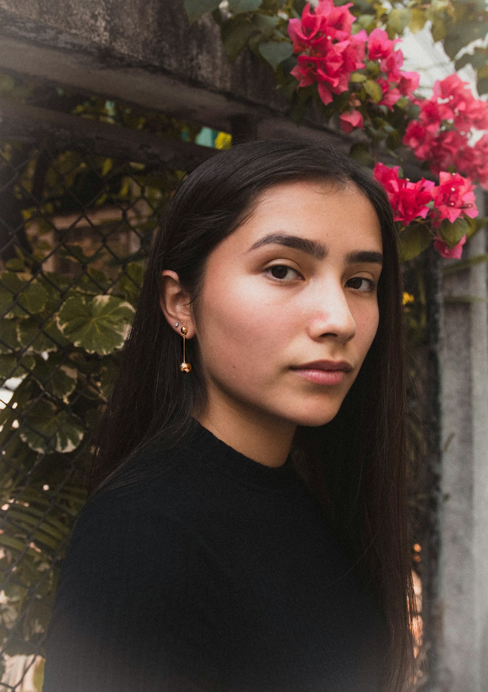 Mujer de pie cerca de flores rojas