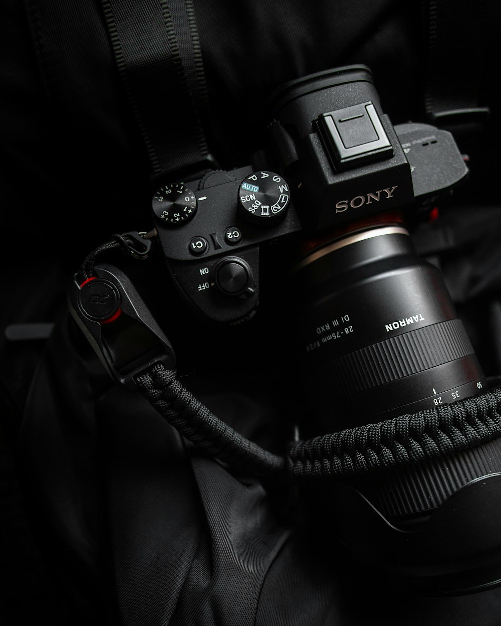 black Sony Alpha DSLR camera with black paracord strap