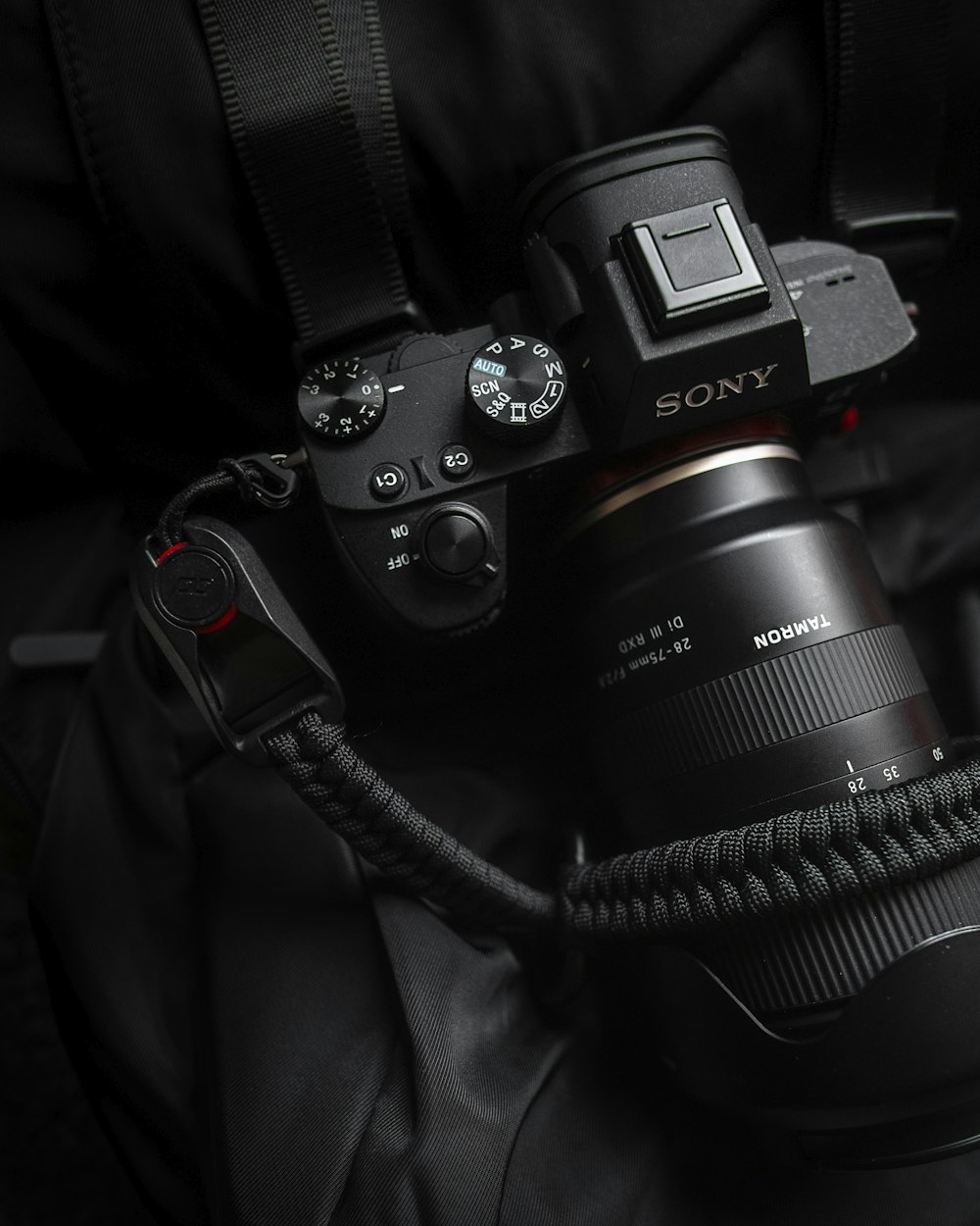 black Sony Alpha DSLR camera with black paracord strap