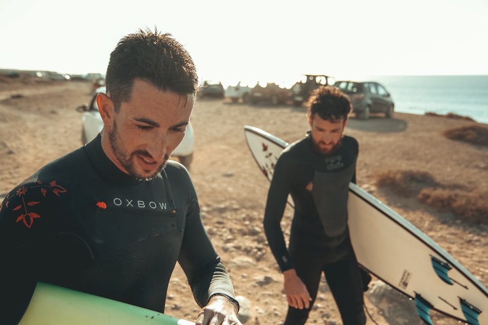 2 uomini con tavole da surf in spiaggia