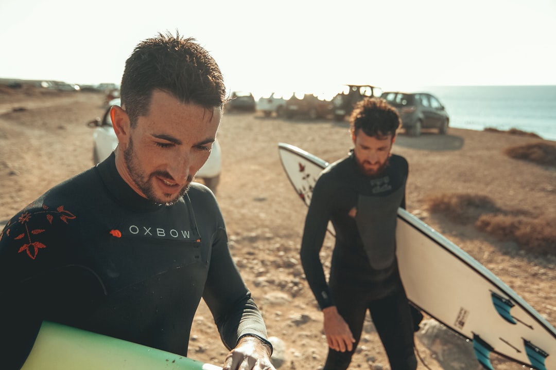 2 men with surf boards in beach,