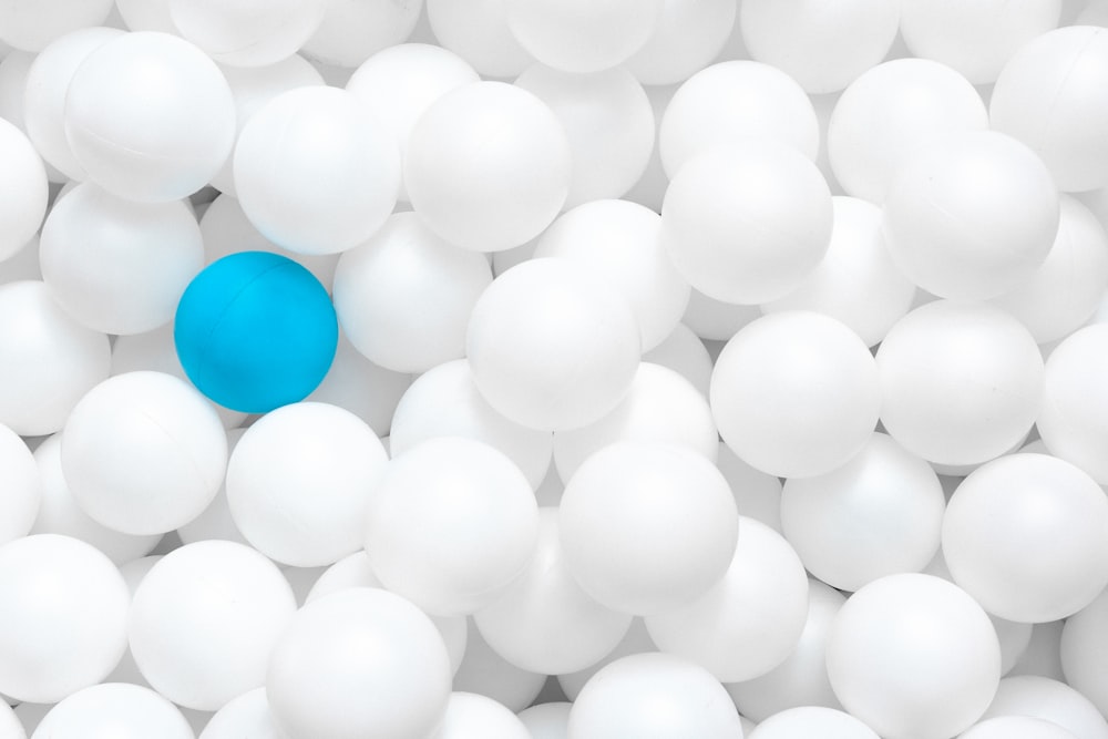 Una bola azul está rodeada de bolas blancas