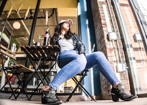 woman sitting on chair with Coca-Cola bottle beside