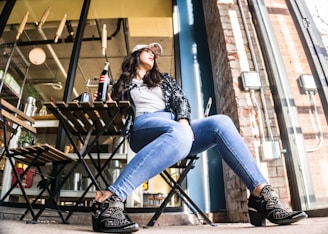 woman sitting on chair with Coca-Cola bottle beside