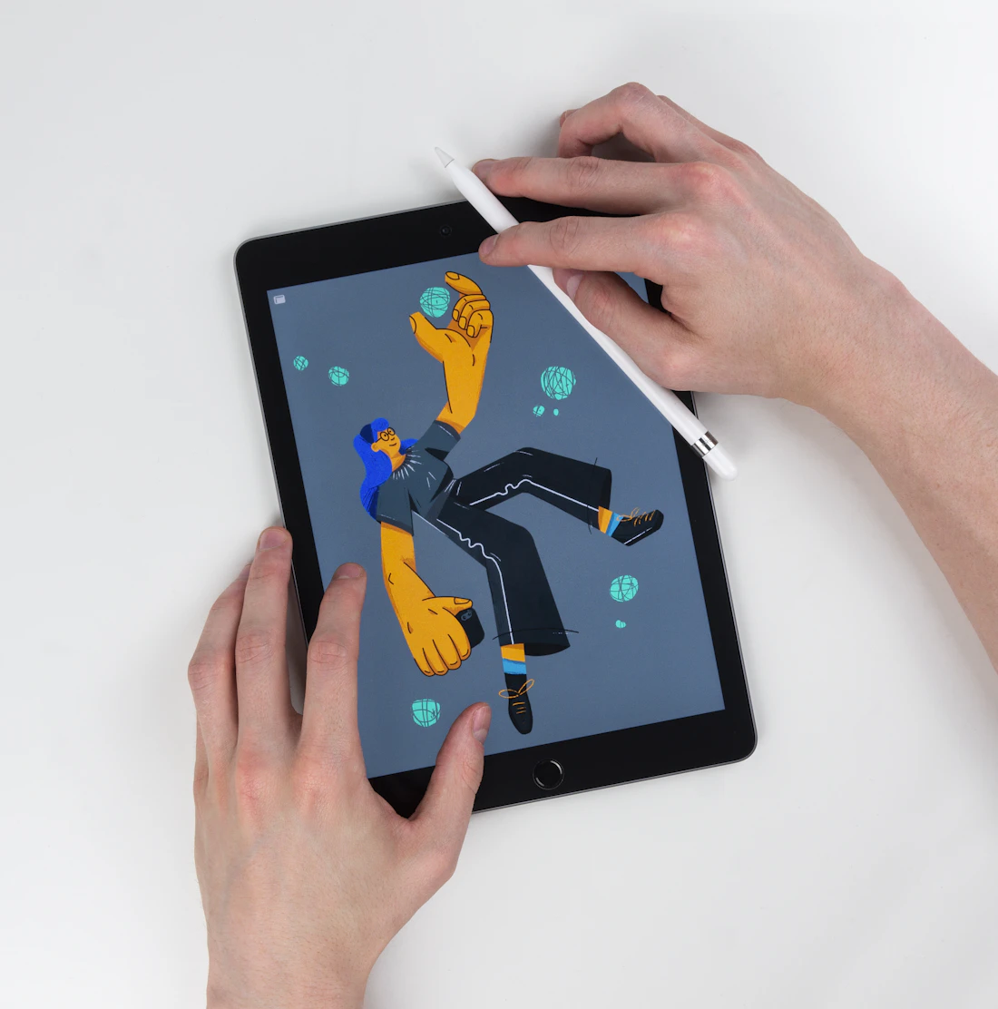 Руки иллюстратора рисуют персонажа на iPad-mini стилусом