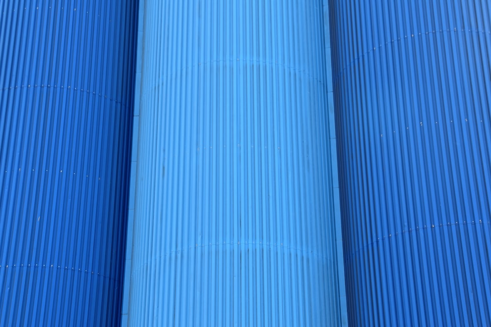 a red fire hydrant in between two blue pipes