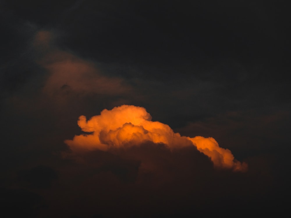 a large orange cloud in a dark sky