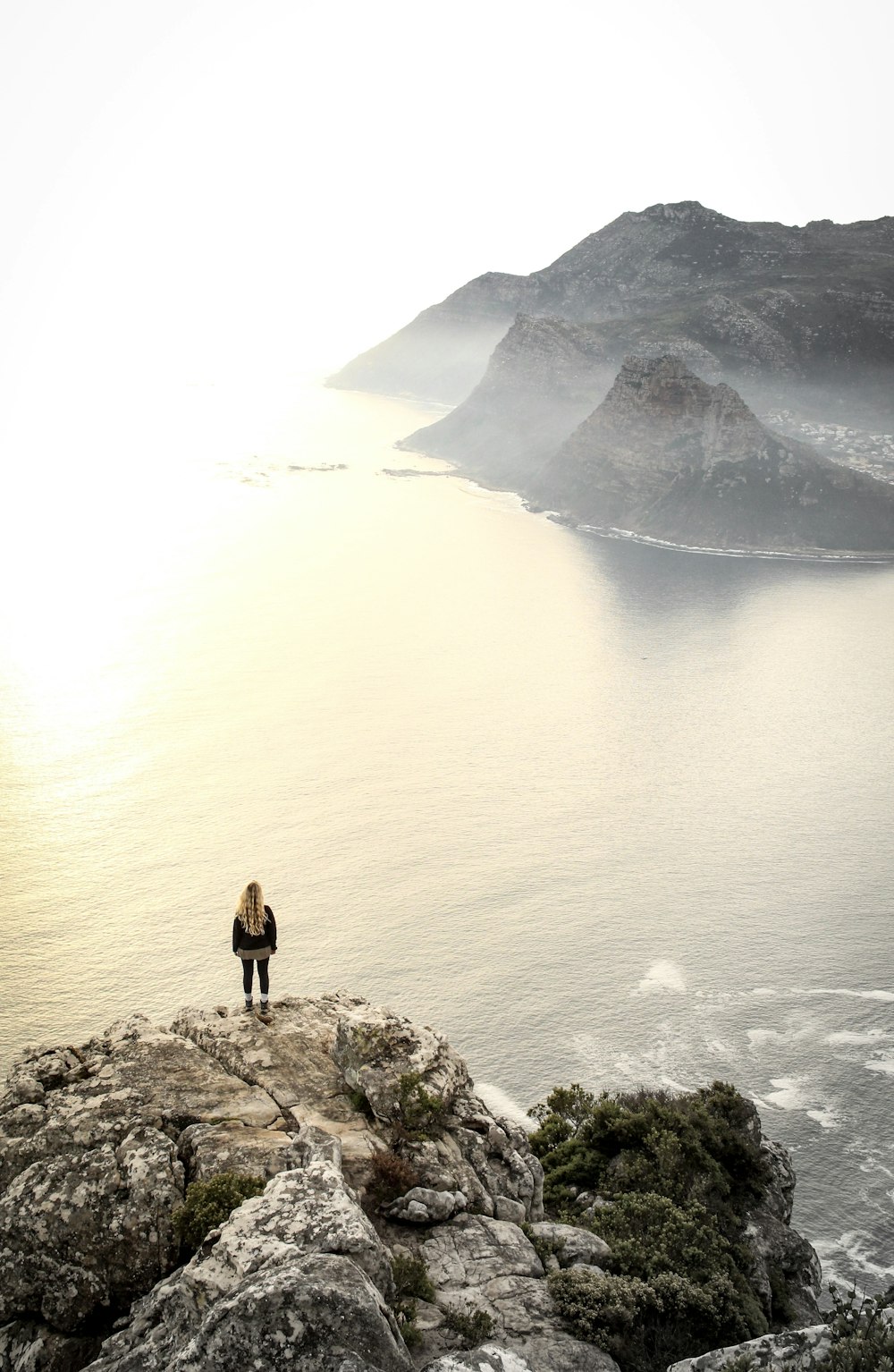 woman standing on sea cliff during daytime