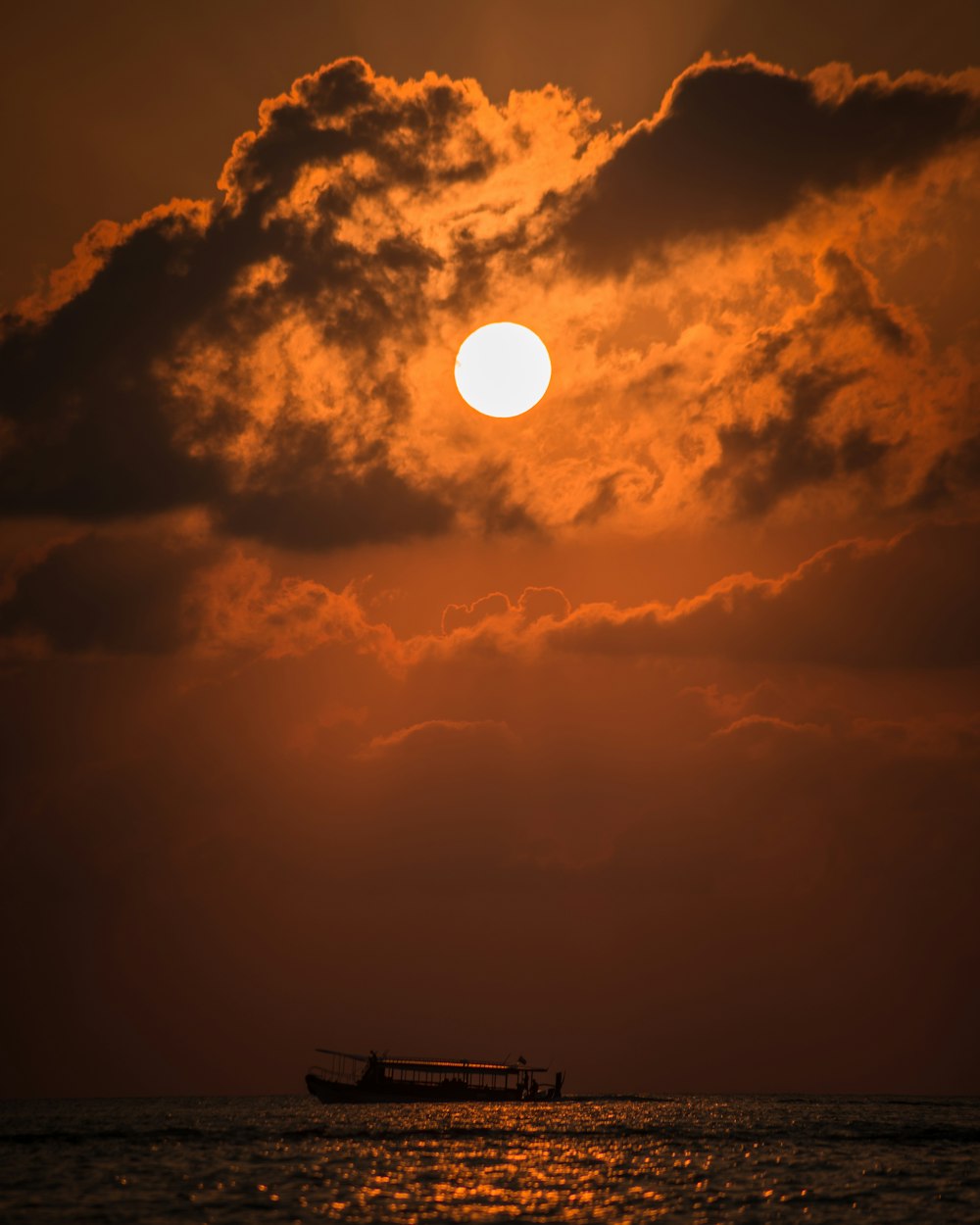 silhouette of boat under moon