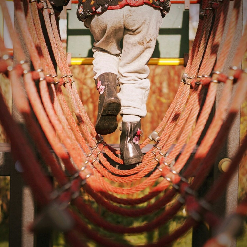 person passing red rope bridge