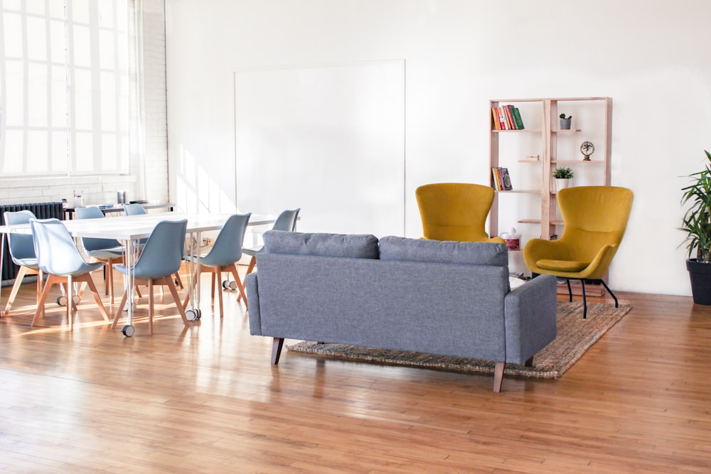 2-seat sofa in front of two armchairs near table with chairs