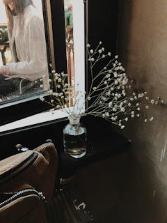 A delicate floral ceramic vessel filled with fresh wildflowers, sitting by a sunlit window.