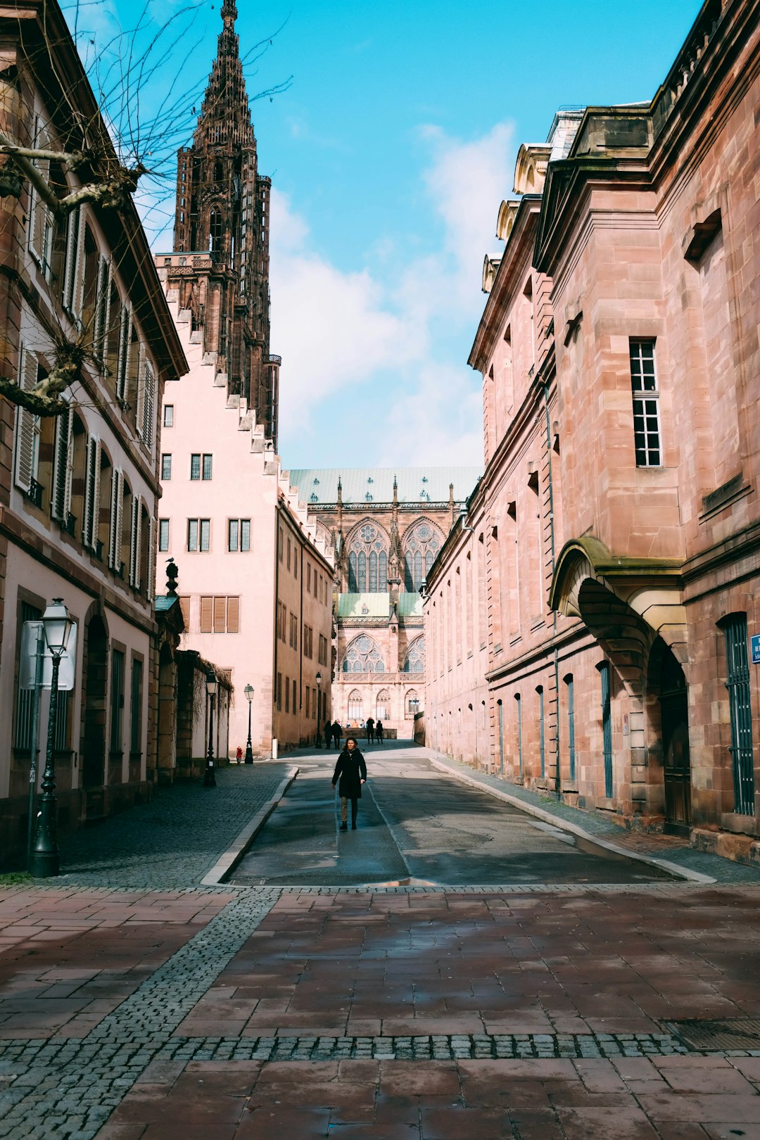 person standing alone on road near buildings