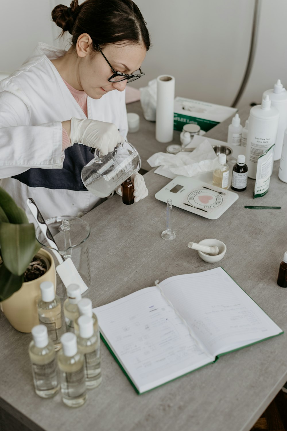 woman mixing liquids while sitting near table