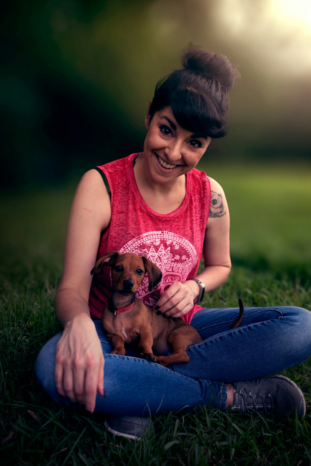 woman in pink sleeveless shirt holding brown puppy
