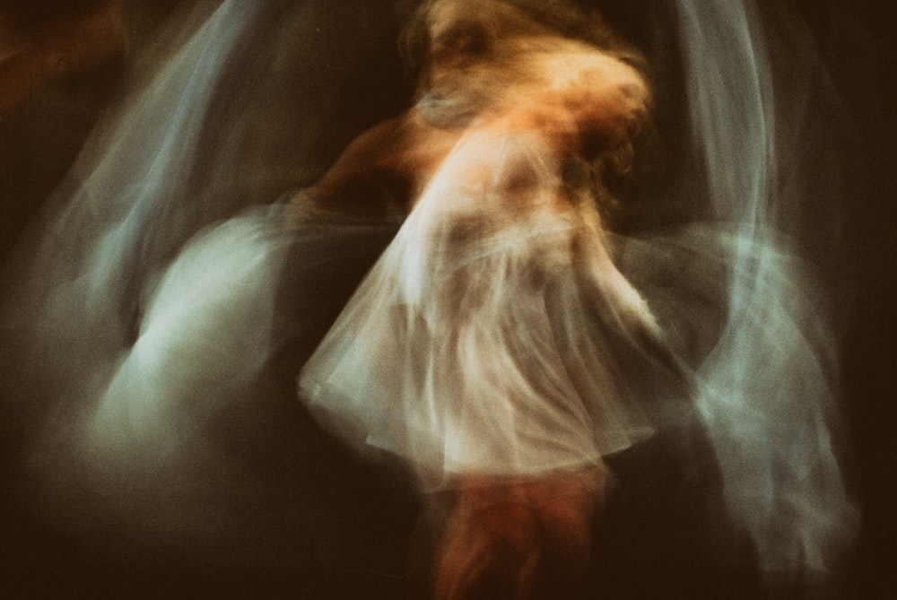 a blurry image of a woman in a white dress