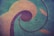 A cracked concrete surface features colorful, swirling geometric patterns incorporating circles, arcs, and leaf-like shapes. The design contrasts against the aged, slightly rough texture of the pavement.