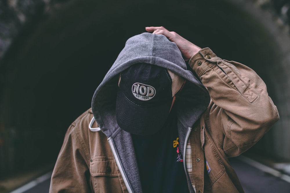 man wearing brown and gray hooded jacket at daytime