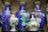 A collection of intricately designed ceramic vases and a lidded pot are displayed together. The vases mostly feature a vibrant blue background adorned with colorful floral patterns, including blossoms in white, pink, and orange hues. The lidded pot is smaller, showcasing ornate details with gold accents and floral designs.