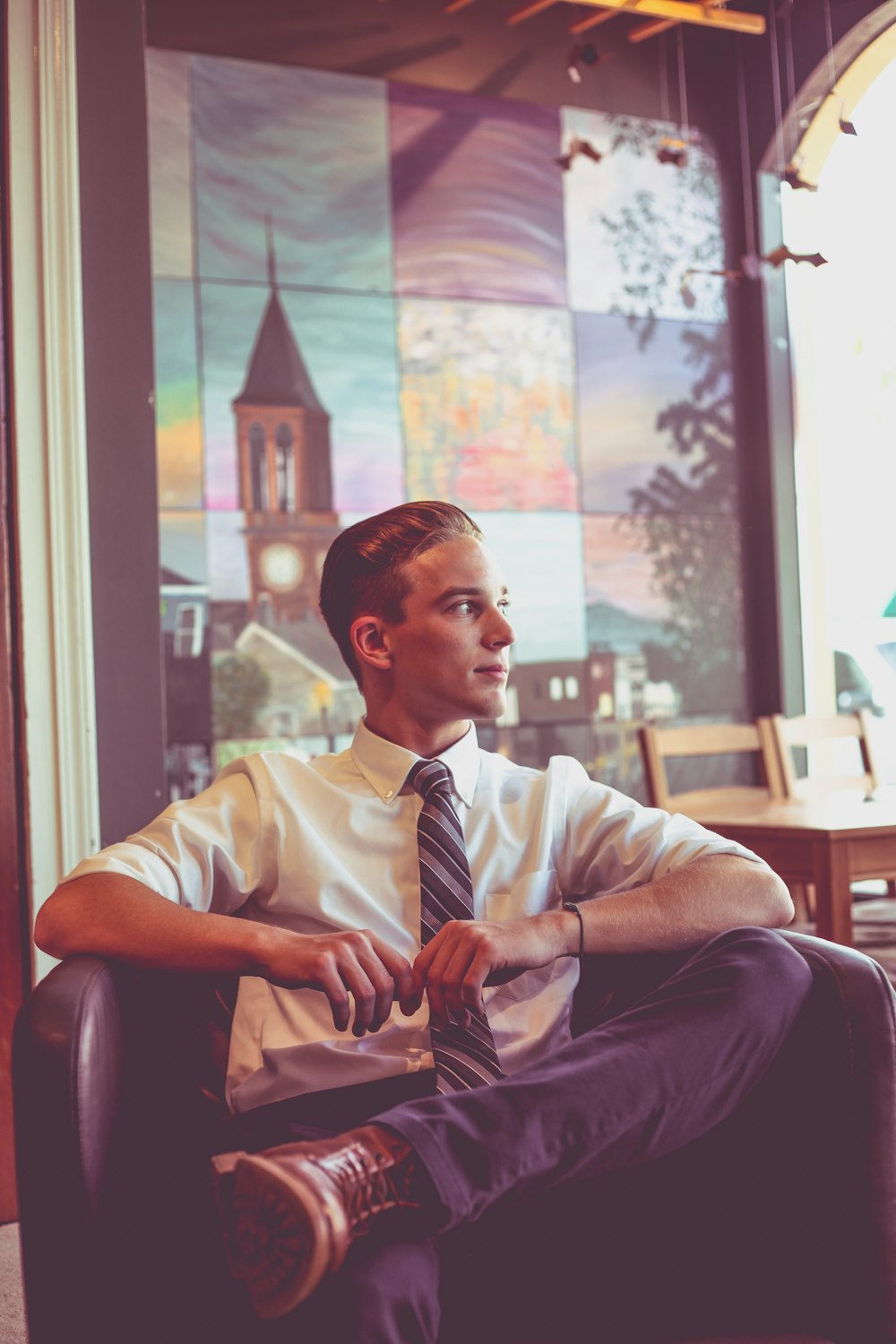 man wearing white dress shirt, necktie and dress pants sitting on floor