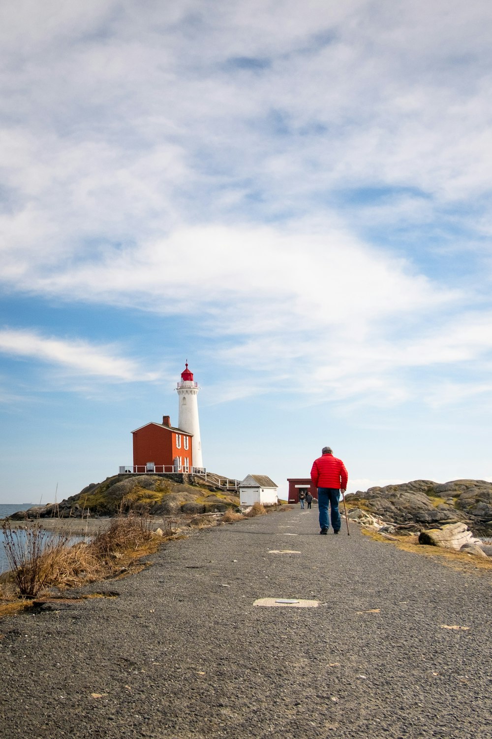 man walking near lighthouse tower at daytime