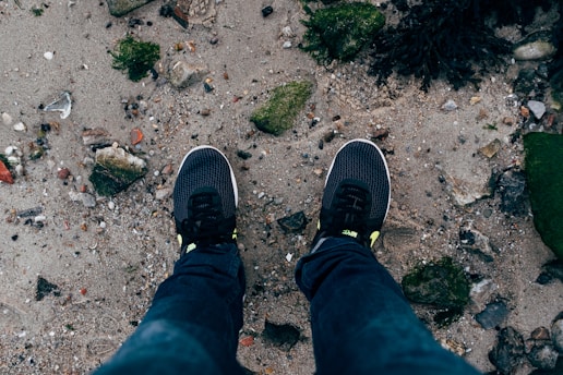 A pair of lightweight wind-ready sneakers on a rocky outdoor trail.