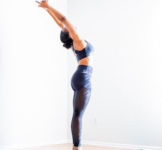 woman stretching wearing black bra and pants