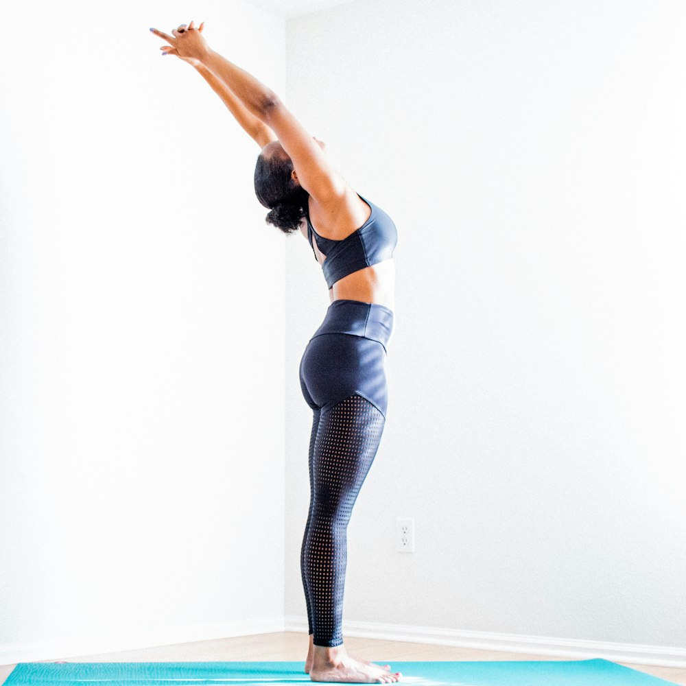 woman stretching wearing black bra and pants